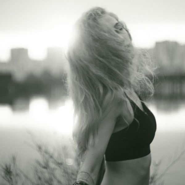 Person doing a flowing yoga movement against a simple background.